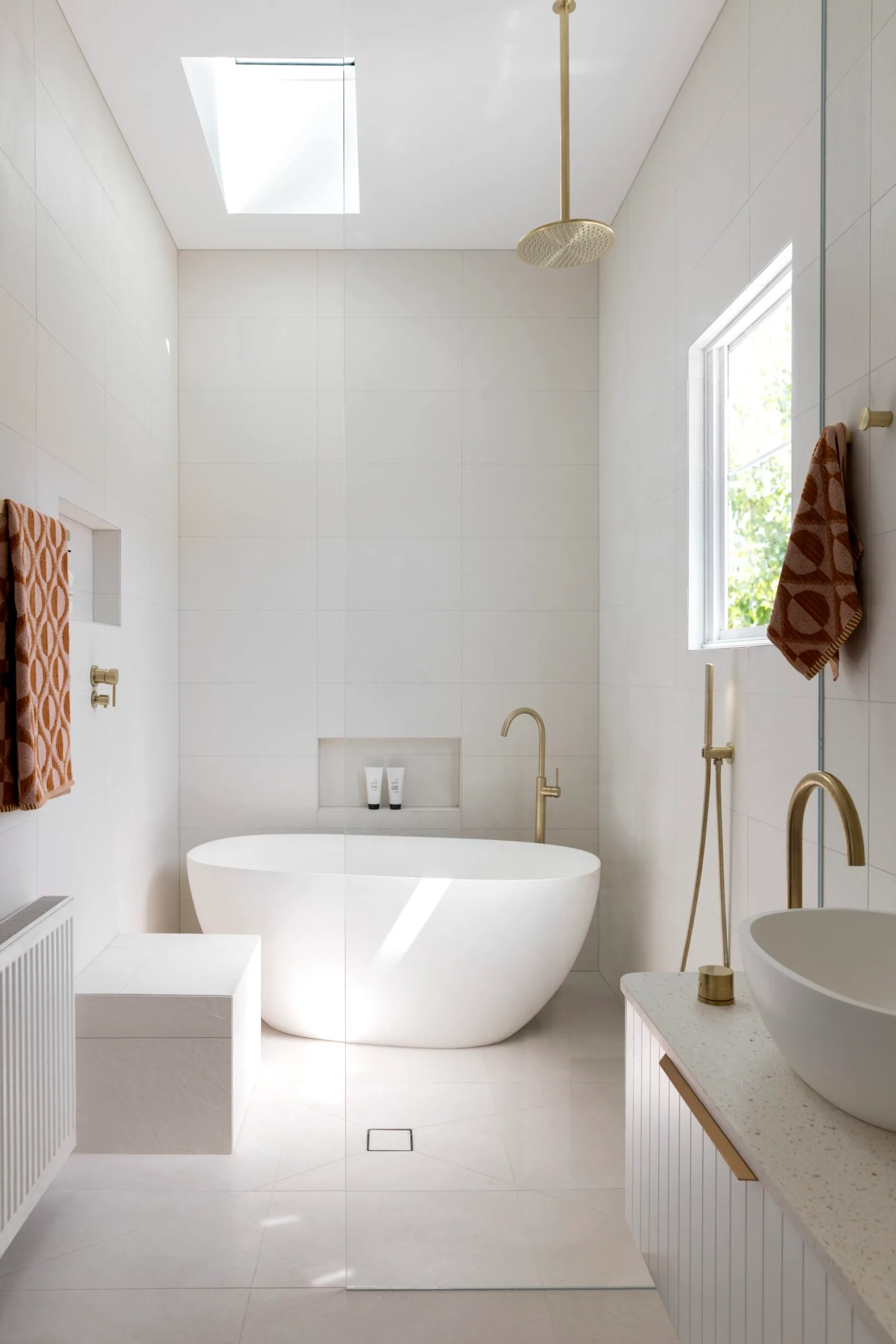 A lighty and airy bathroom with a skylight and freestanding bath. 