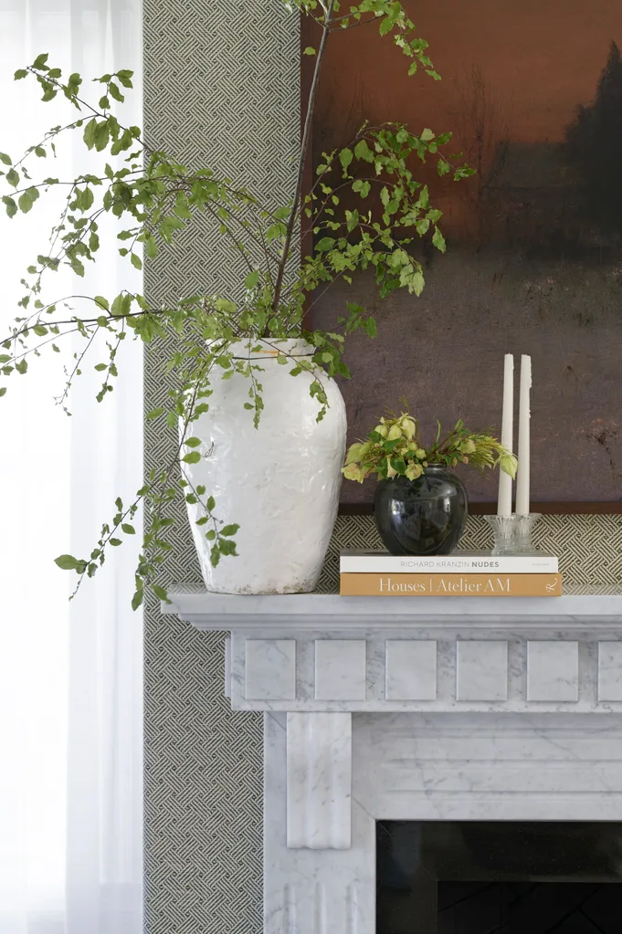 Fireplace mantel with vases candles and artwork