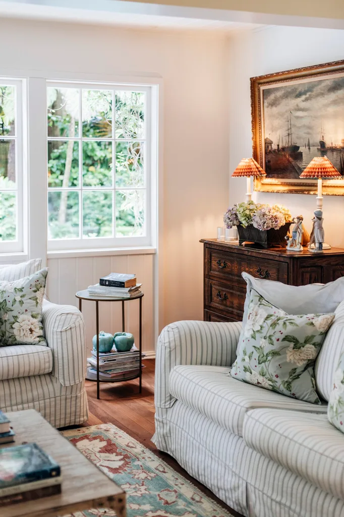 Art, lamps and a striped couch fill this living room.