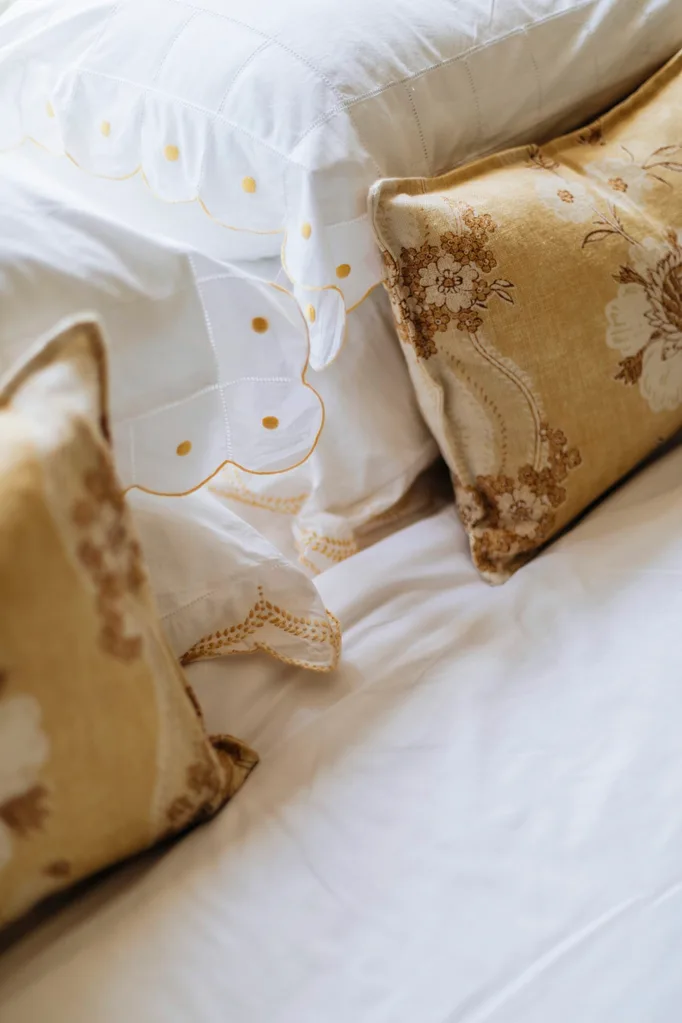 Yellow cushions on a bed in a Nantucket style home in Palm Beach.