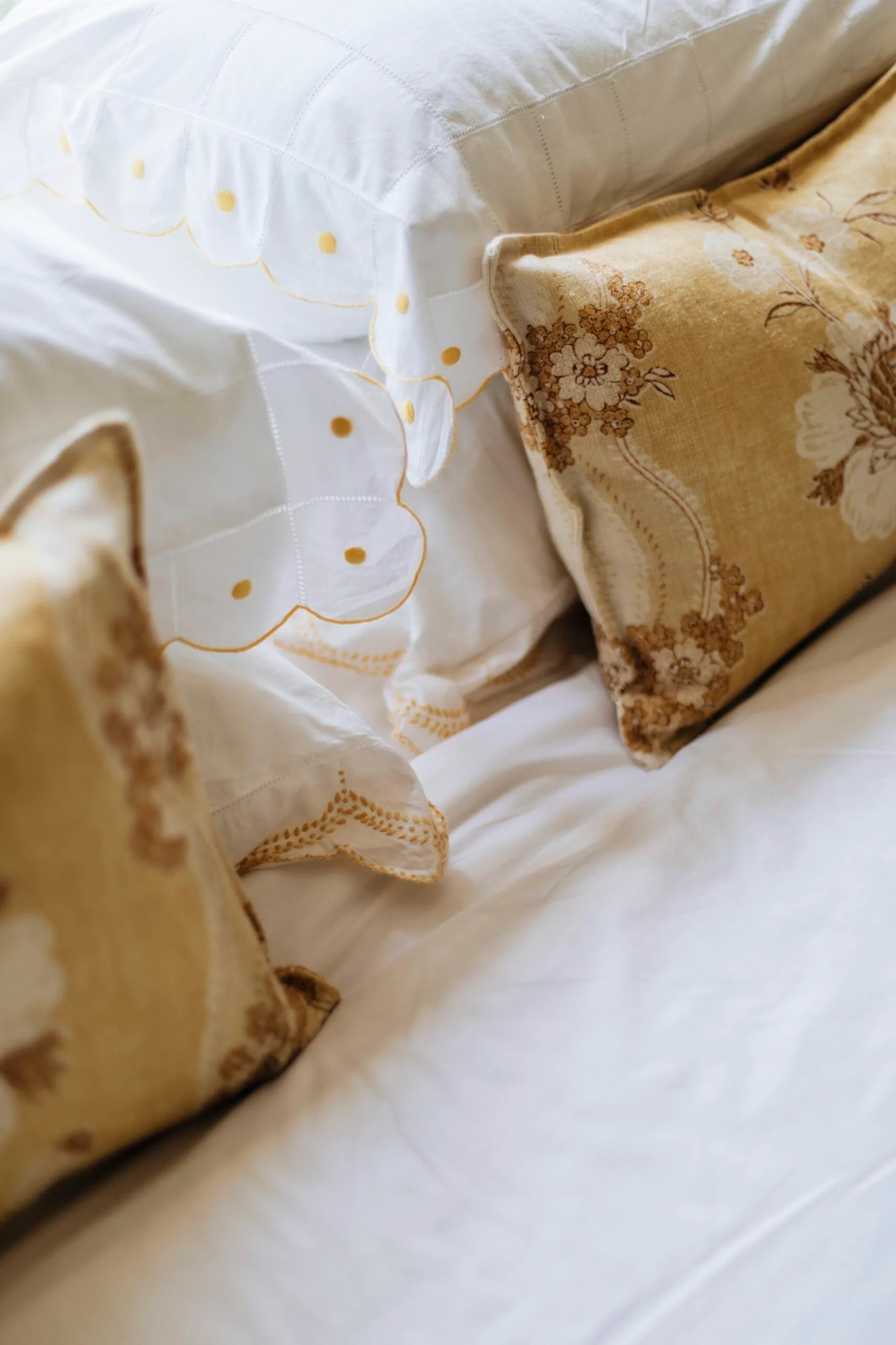 Yellow cushions on a bed in a Nantucket style home in Palm Beach. 
