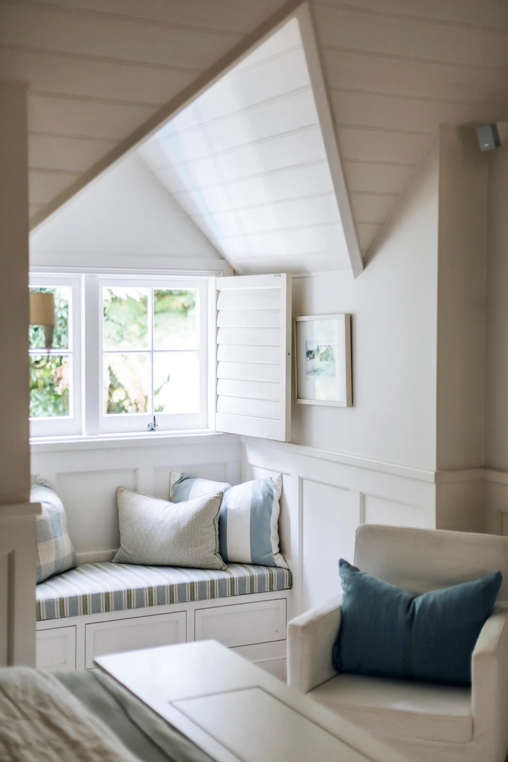 A window seat in the bedroom of a Nantucket style home. 