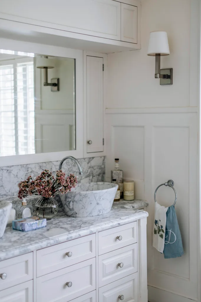 A marble countertop in the bathroom with wall wainscoting.