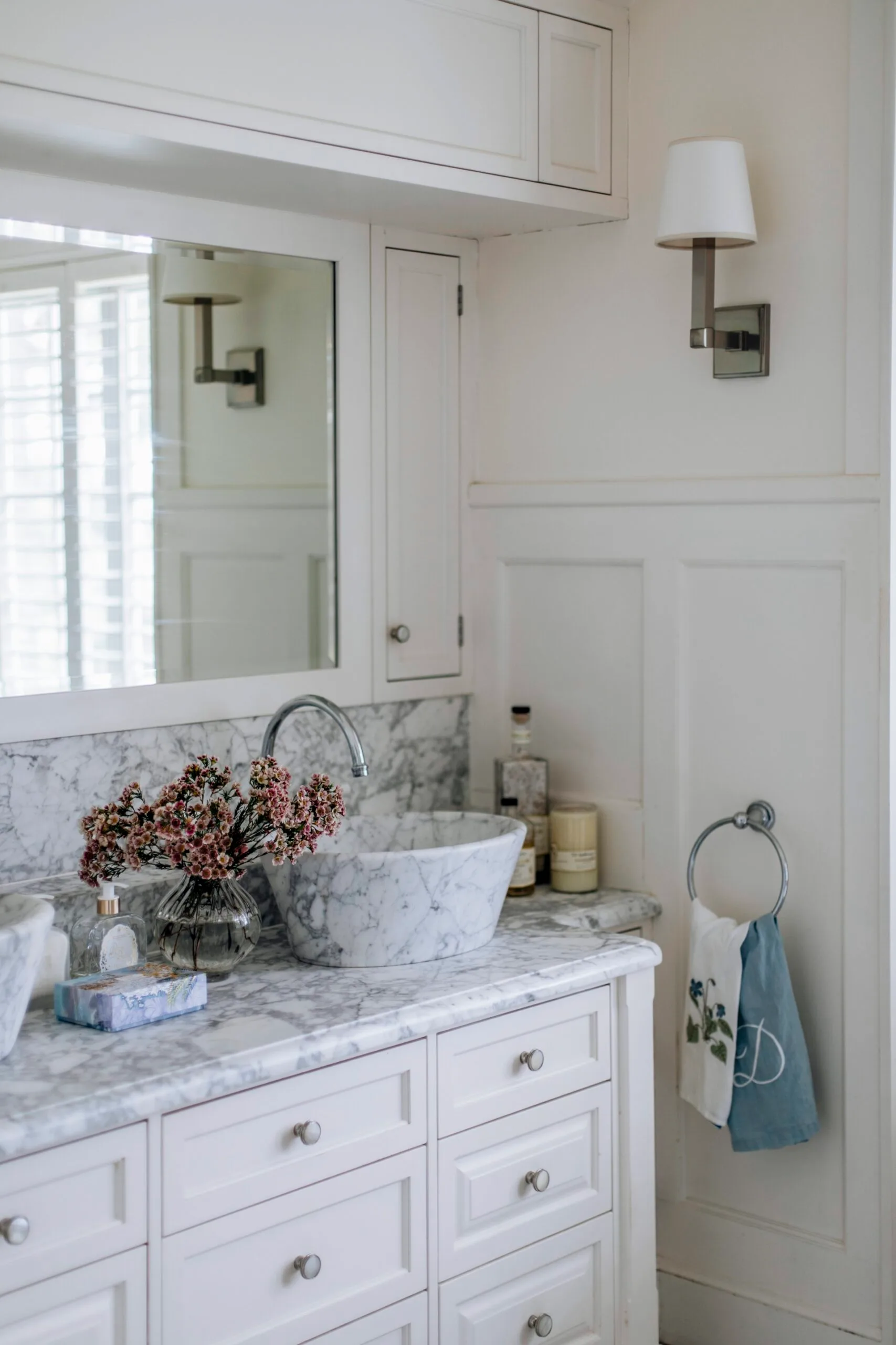 A marble countertop in the bathroom with wall wainscoting. 