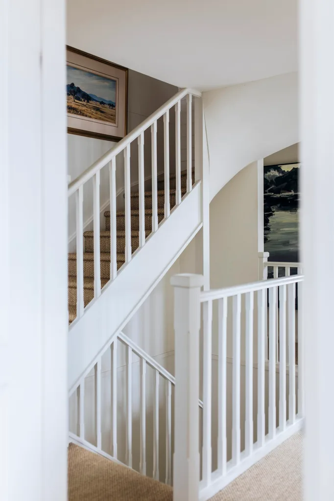 Sisal carpet runs up the stairs in this Nantucket style home.