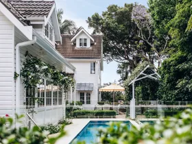 A tropical alfresco area with a pool and climbing vines.