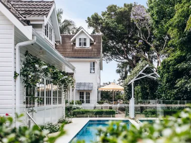 A tropical alfresco area with a pool and climbing vines.