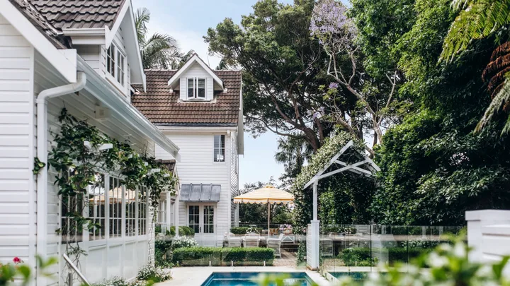 A tropical alfresco area with a pool and climbing vines.