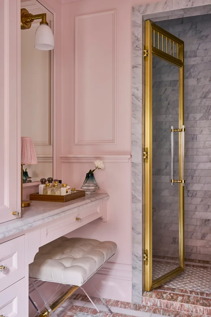 A pink bathroom with a dressing table area.