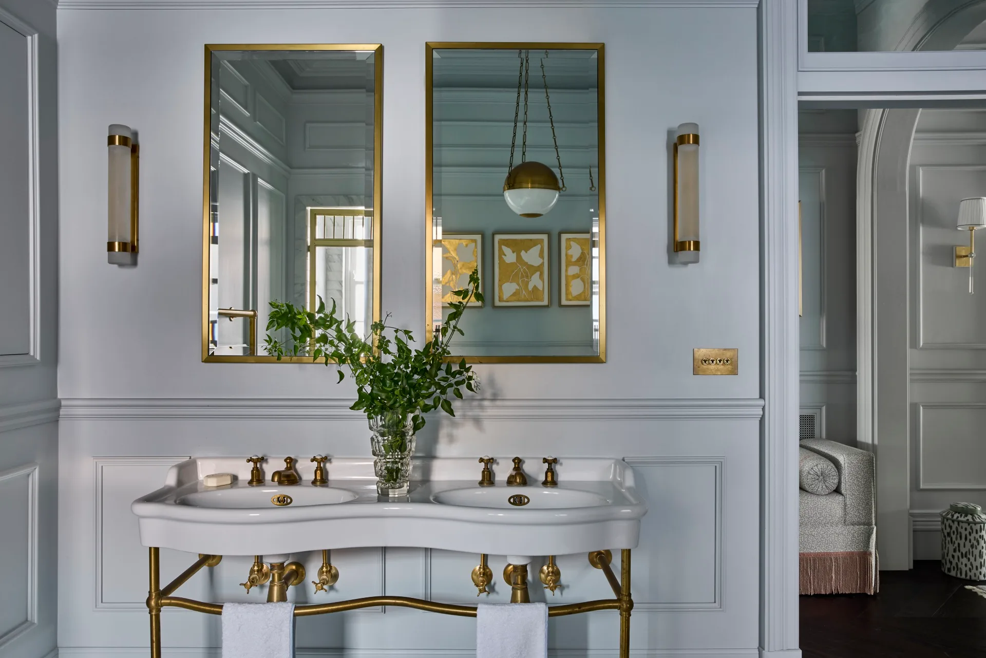 A pale blue bathroom with a brass vintage sink. 