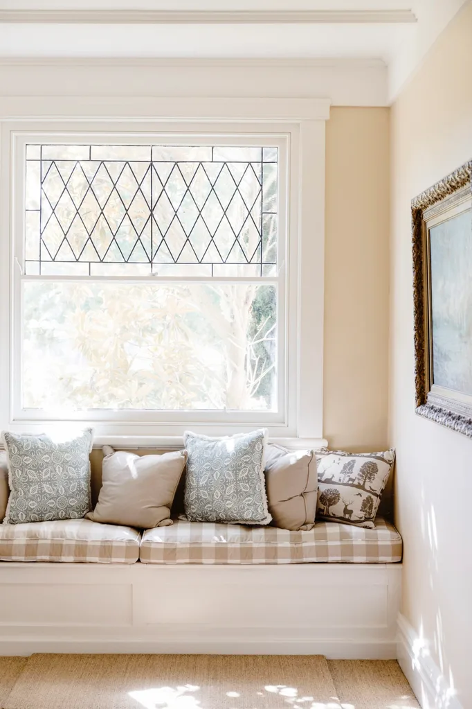 A window seat with a brown checkered cushion.