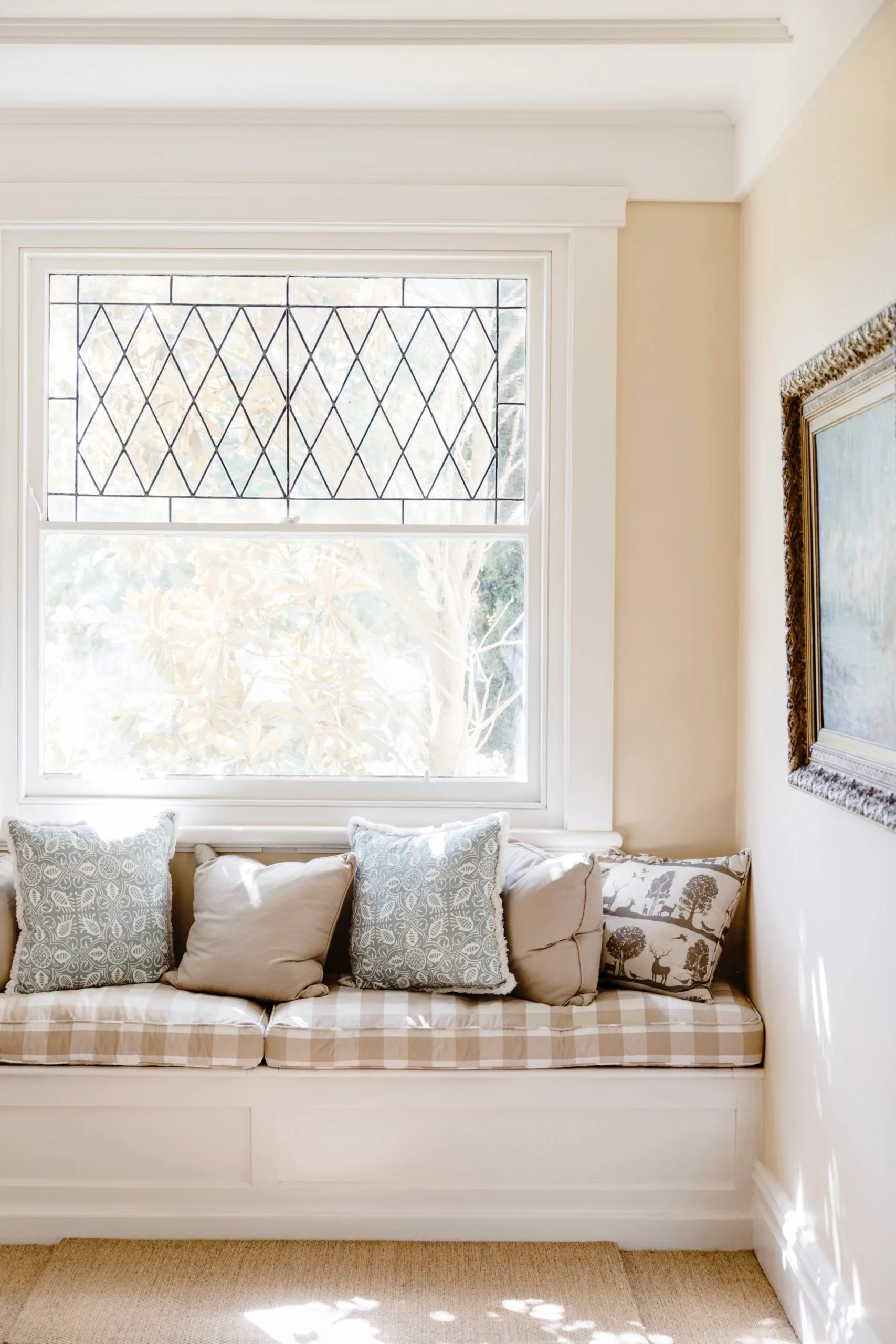 A window seat with a brown checkered cushion. 