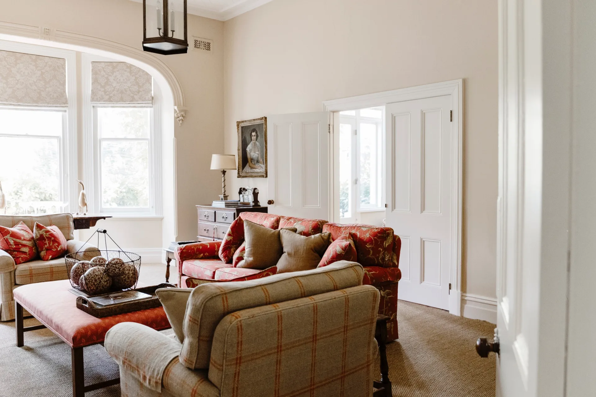 A living room with fabric sofas and an upholstered ottoman. 