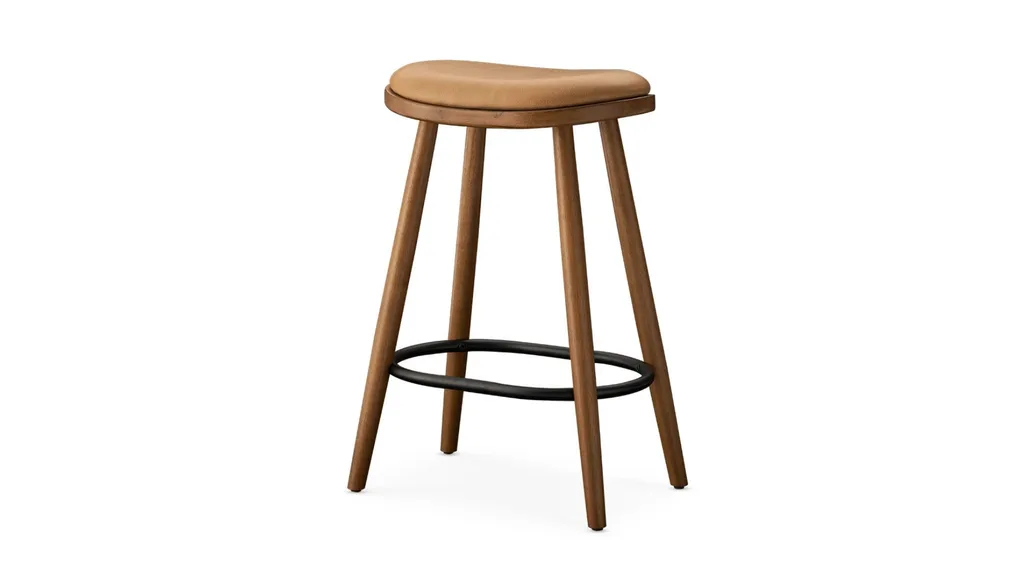 A bar stools with wooden frame, black leg rests and a curved seat upholstered in brown/tan leather.