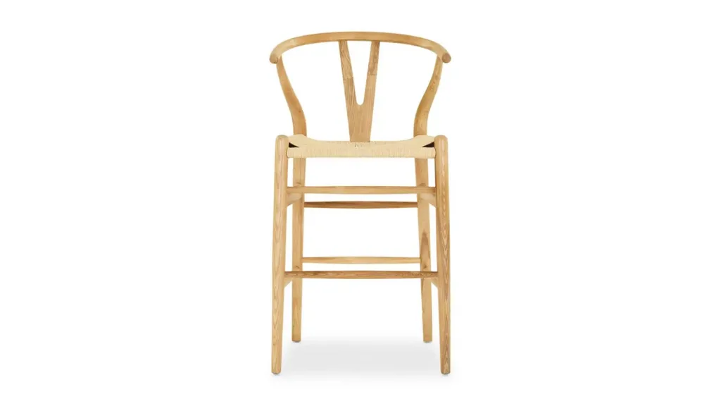 An oak bar stool with rattan seat, curved backrest and leg rests.