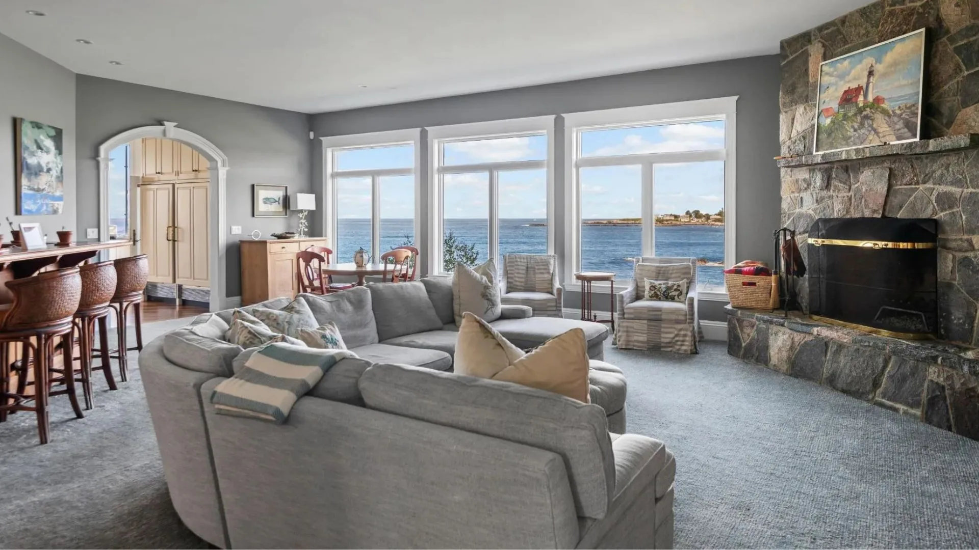 A living room with a fireplace overlooking the ocean. 