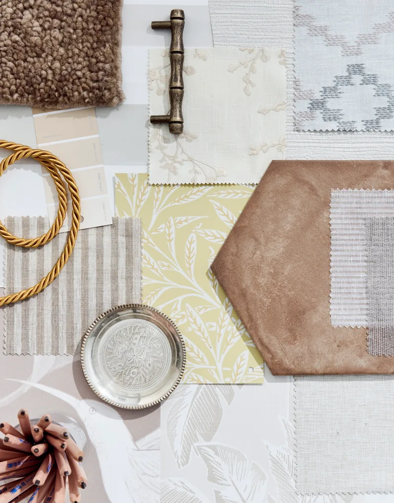 A moodboard with a neutral palette. Samples of blinds are positioned beside twine and a glass of sharpened pencils.