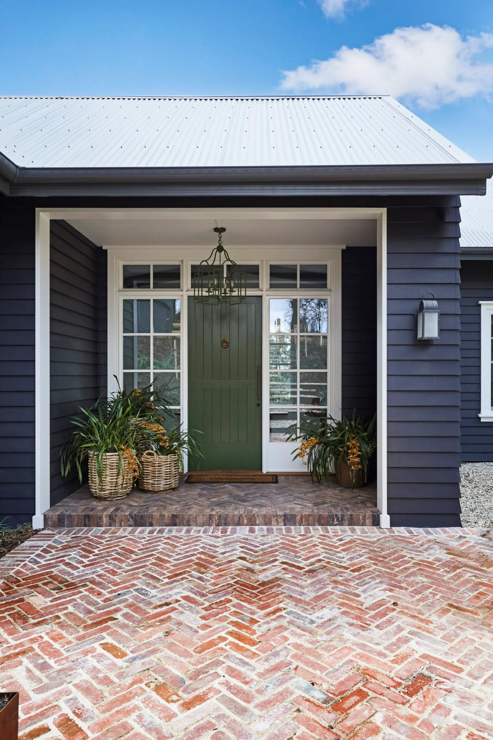 The green front door of a navy modern farmhouse build.