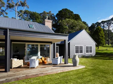 The exterior of a modern farmhouse on the Mornington Peninsula and its back deck.