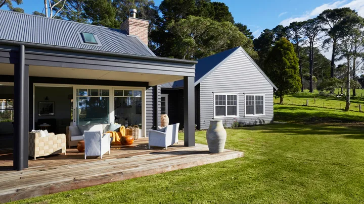 The exterior of a modern farmhouse on the Mornington Peninsula and its back deck.