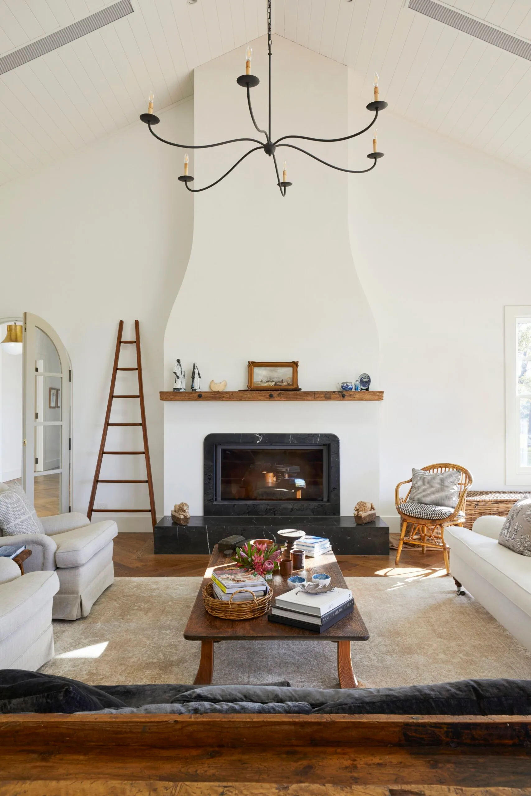 A modern farmhouse living room with a white fireplace and organic materials. 