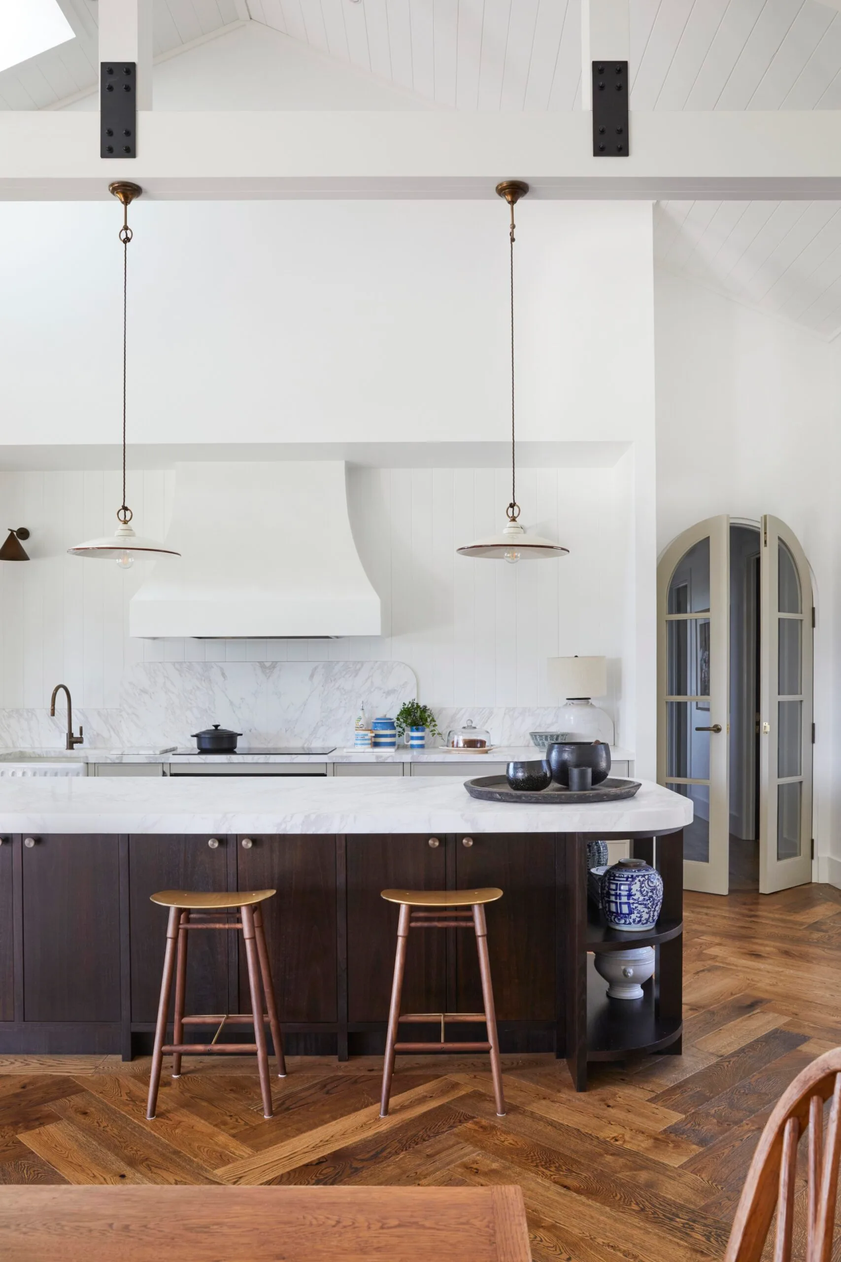 A modern farmhouse kitchen with a stone island and pendant lighting. 