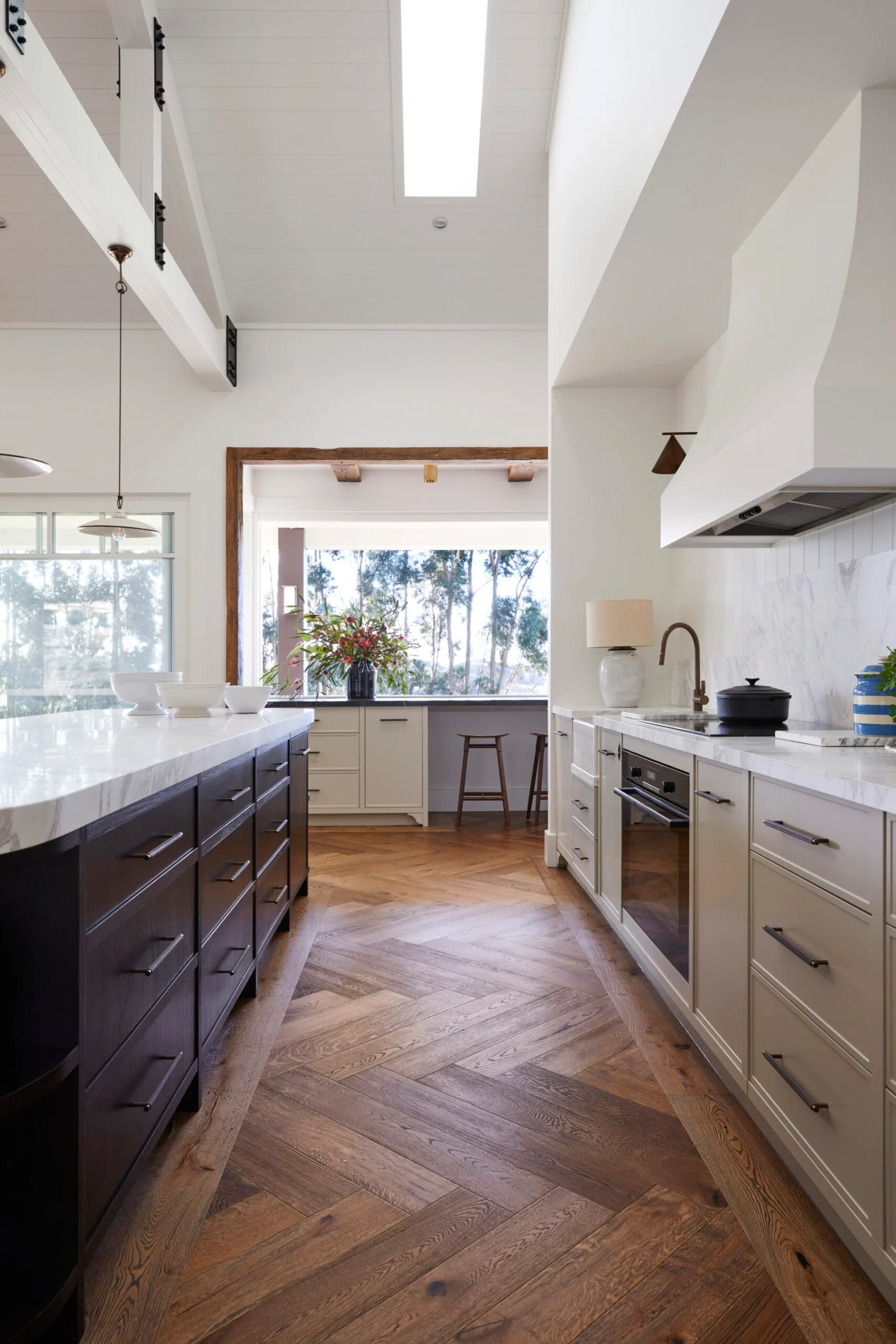 A modern farmhouse kitchen with an island and timber flooring. 