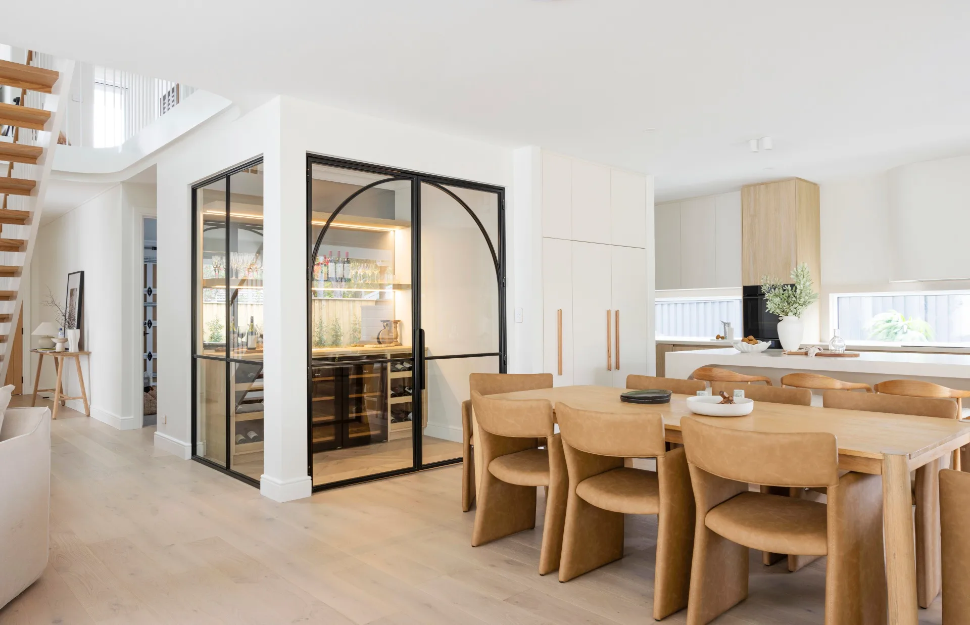 The open plan kitchen, dining and wine room inside a Oak and Orange new build. 