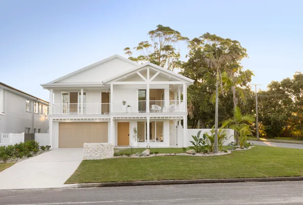 Two storey white home facade with turfed front lawn built by Oak and Orange.