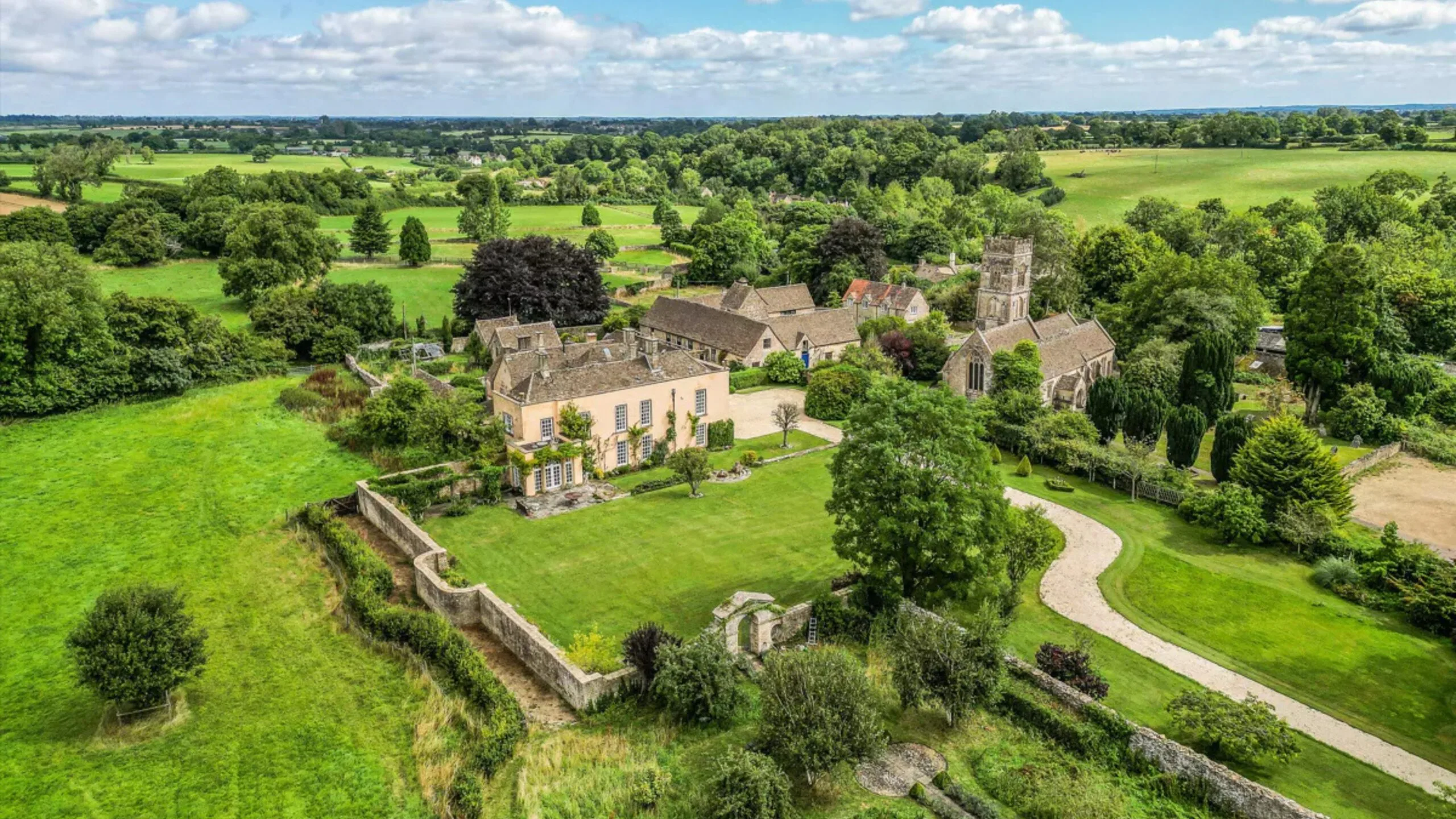 A grand stone manor house, built in 16th Century style with original Tudor features at the rear. Grounds surround the home with trees, hedges, bushes and lush grass. This house was the filming location of the Bennet family house in the BBC adaptation of Jane Austen's Pride and Prejudice.