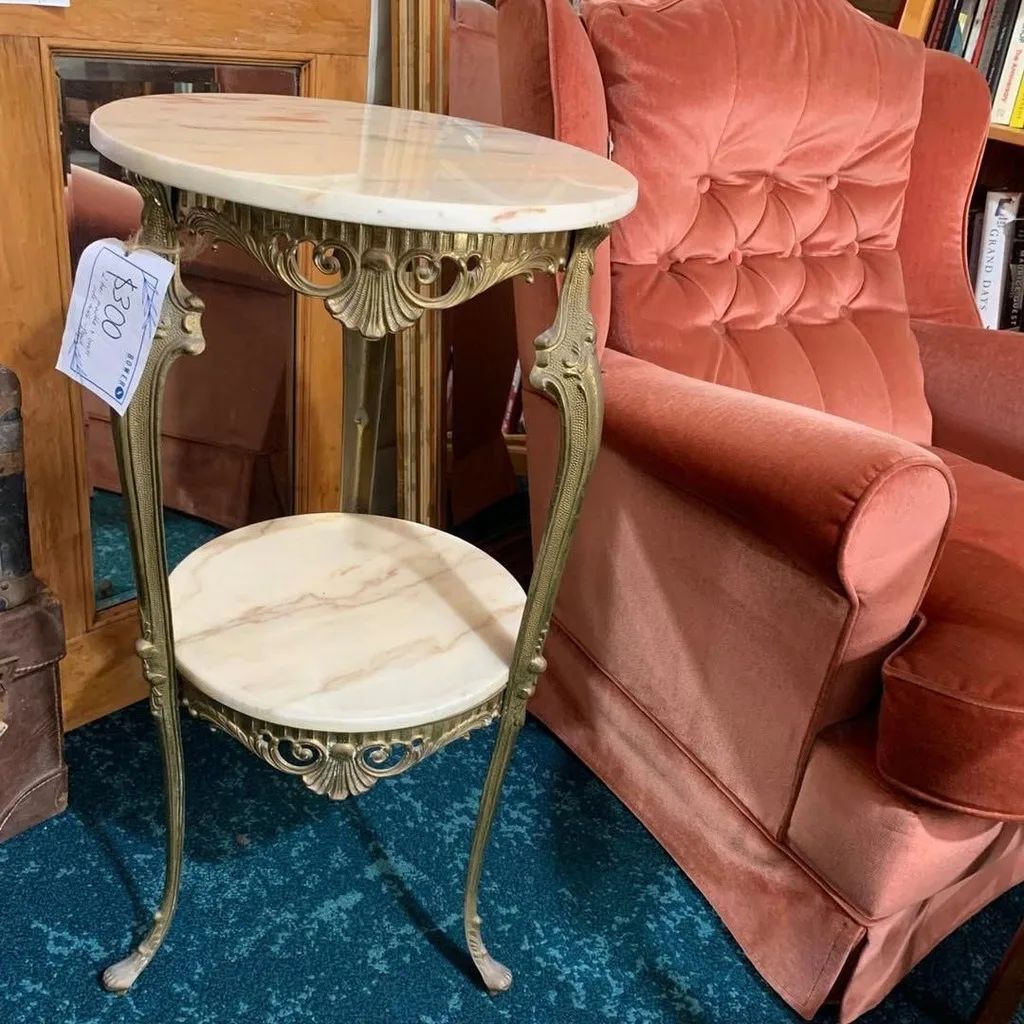 A marble side table and red armchair in The Bower second hand store in Sydney.