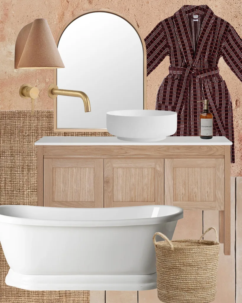 Bathroom collage with a wooden vanity, white vessel sink, brass faucet, woven basket, robe, wall light, and freestanding tub.