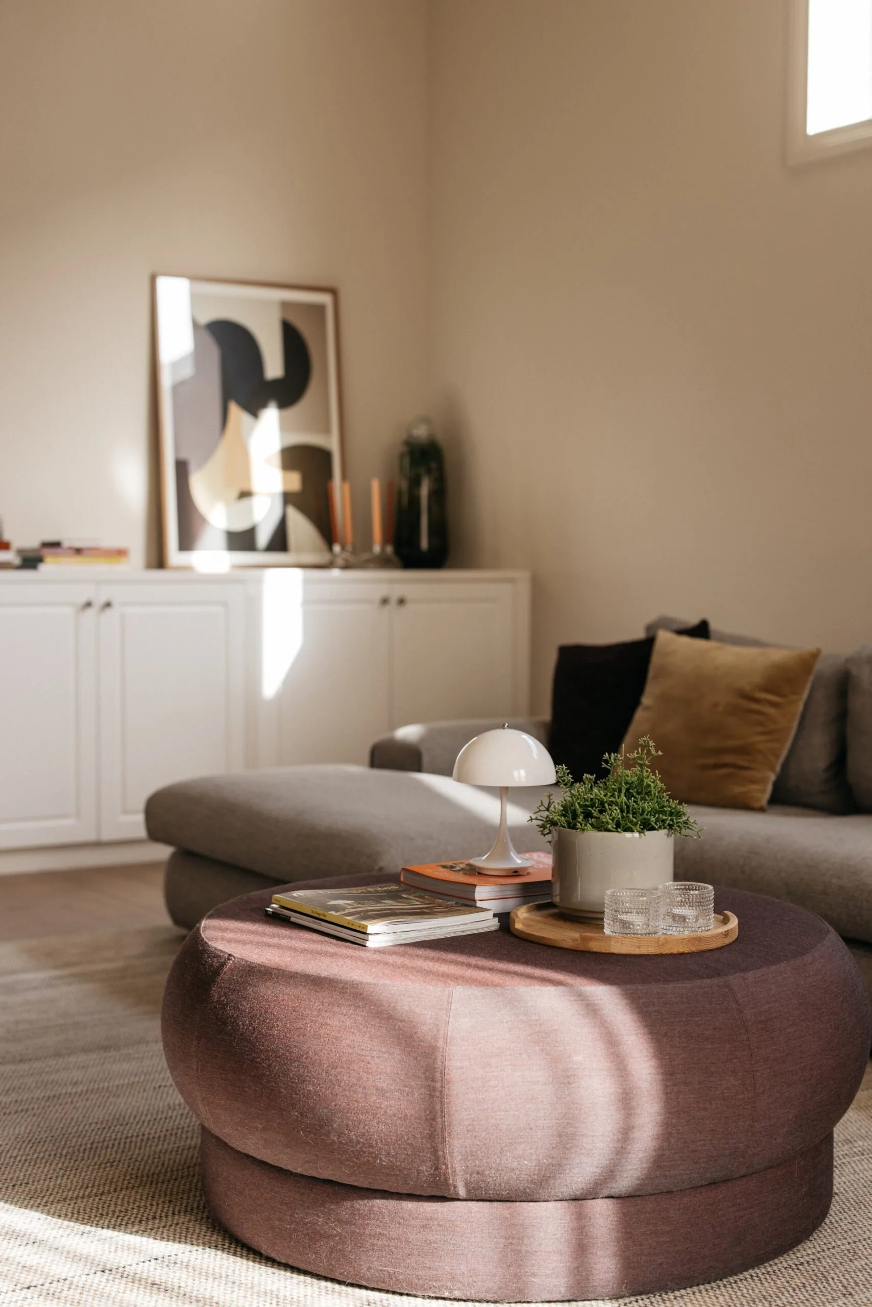 Family room featuring a brown Anaca Studio ‘Toulouse’ ottoman and a Jardan sofa.