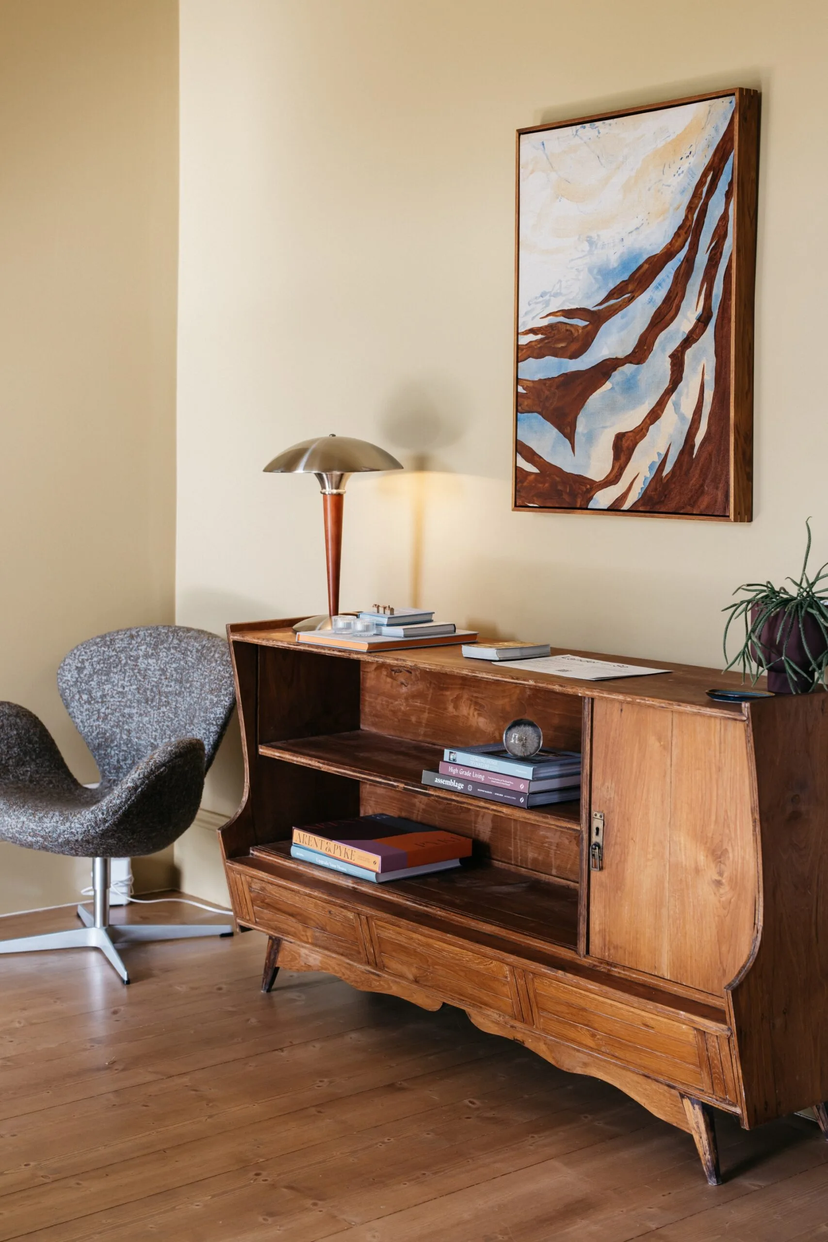 Heritage home renovated in Scandinavian style with an entryway featuring a midcentury timber console, walls painted Dulux Osso Bucco and artwork by Hannah Nowlan.