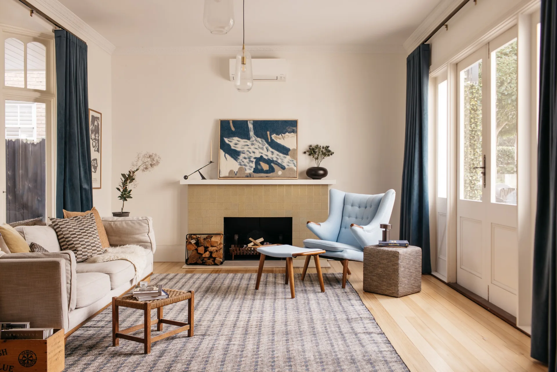The living room in a heritage home renovated in Scandinavian style with a neutral palette and vintage furniture.