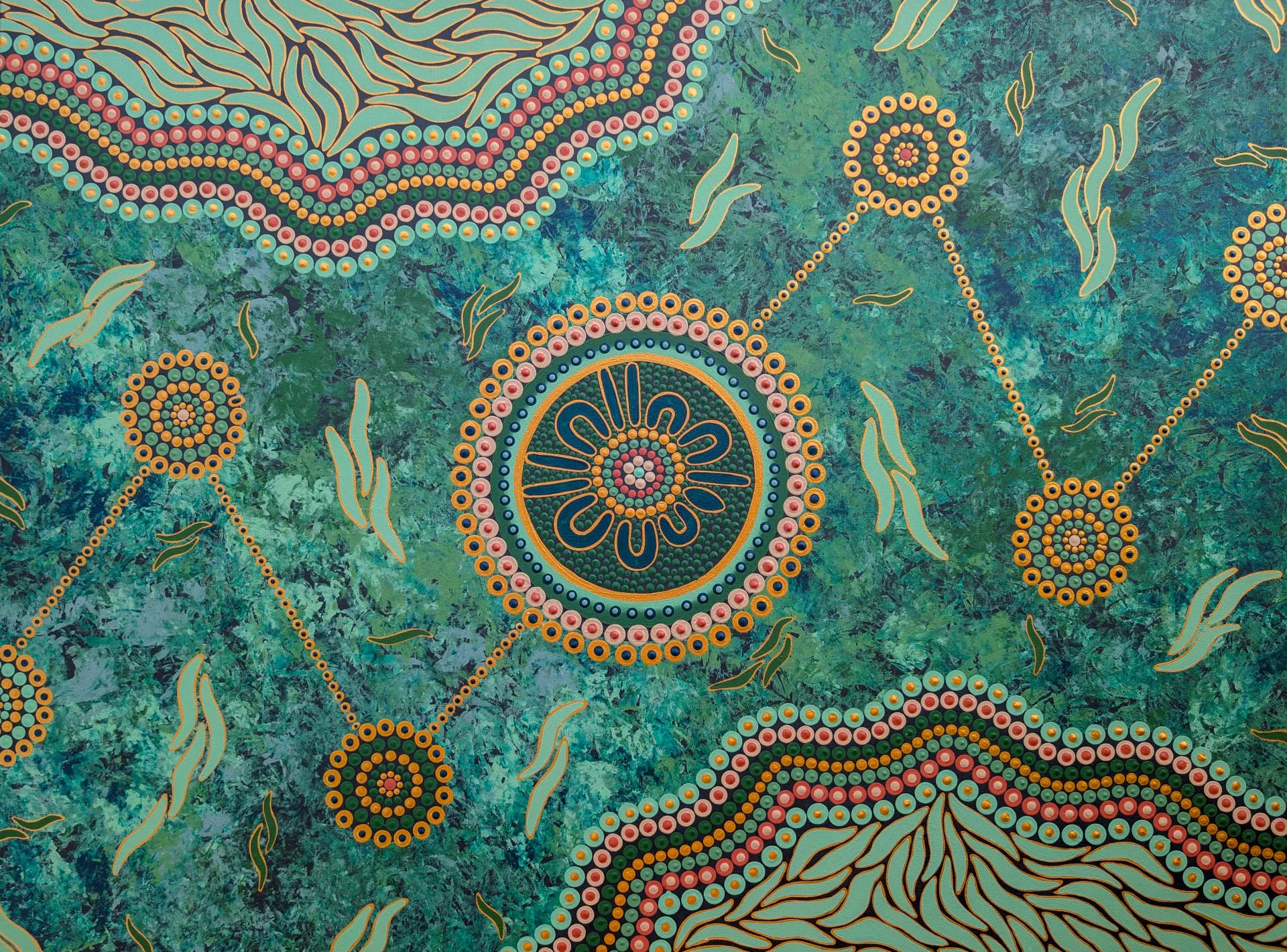 An Indigenous painting featuring blues, reds, yellows and greens.