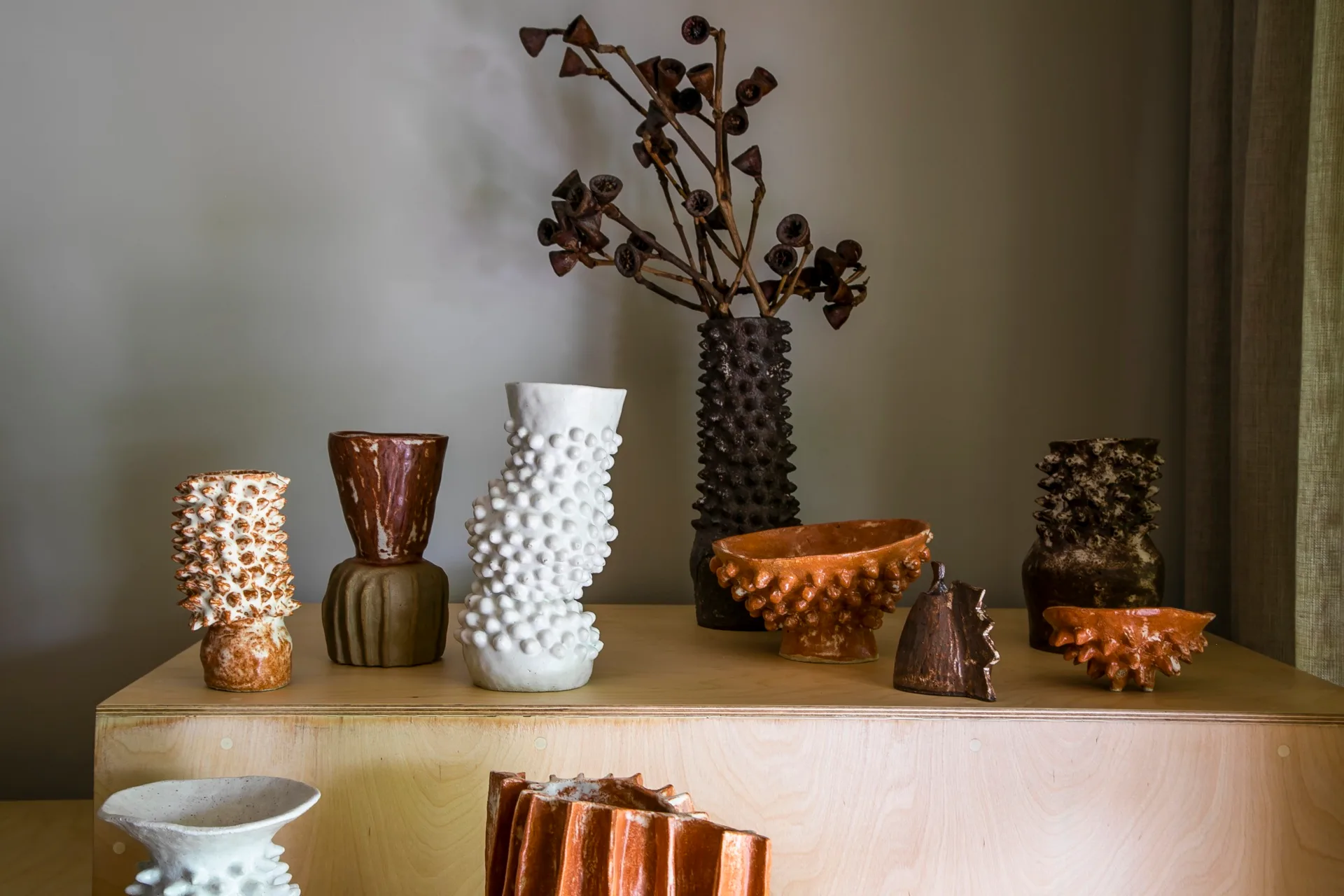 A wooden table decorated with textured vases and vessels.
