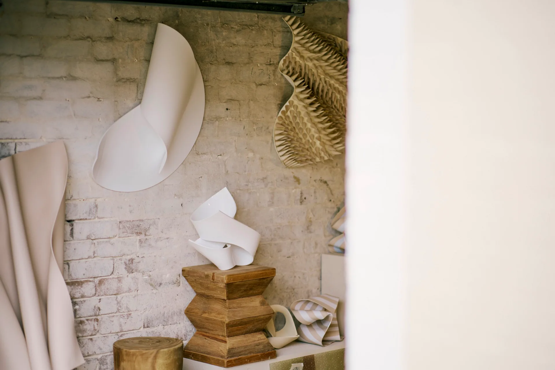 An image of a studio with a brick wall and polymer sculptures decorating the space.