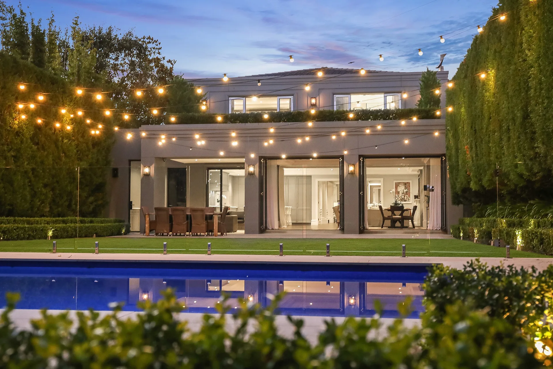 Nicole Gazal O’Neil’s backyard and garden features a pool, a lawn and fairy lights.