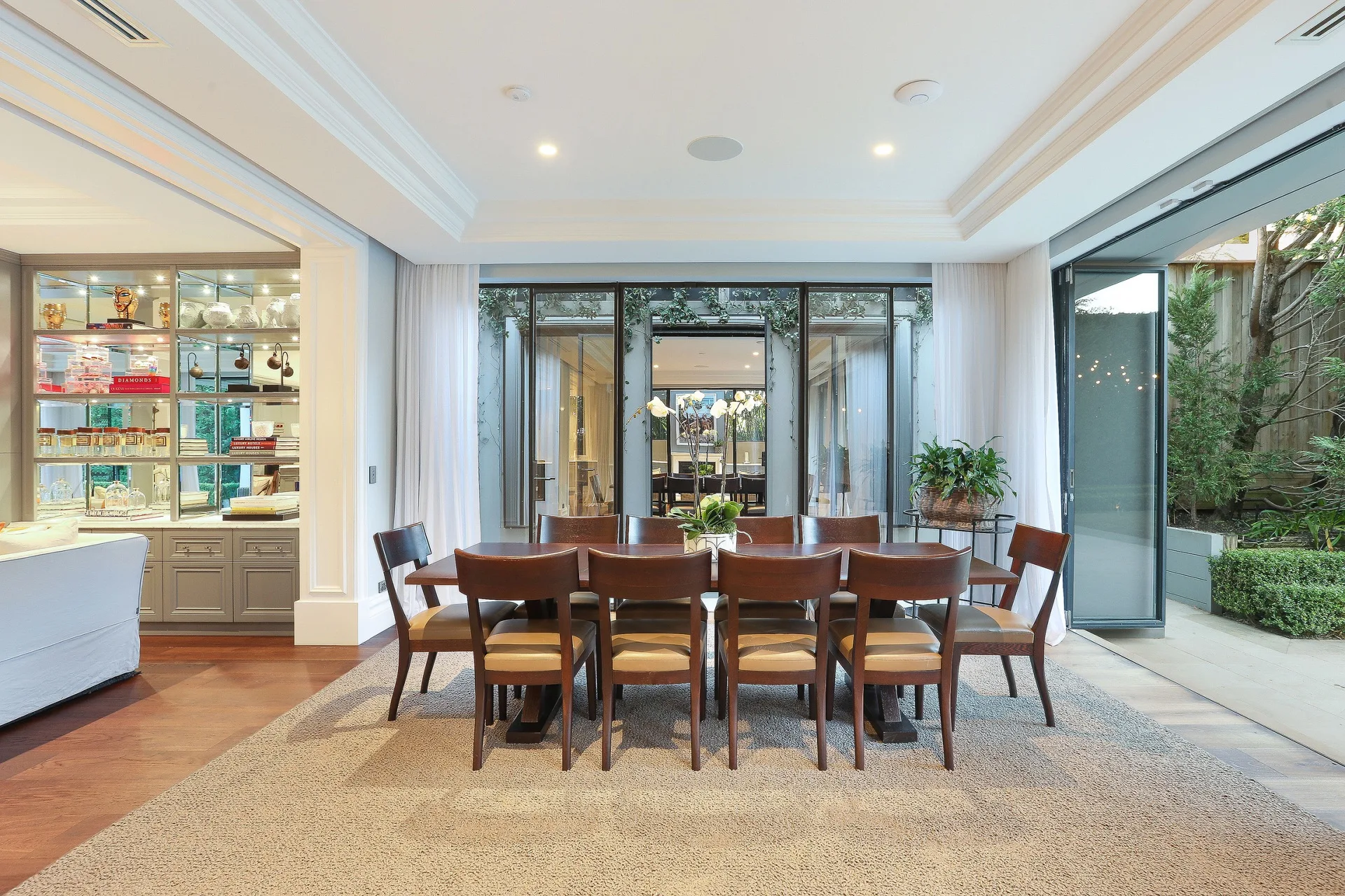 Nicole Gazal O'Neil's casual dining room with timber chairs and table, and a beige rug.