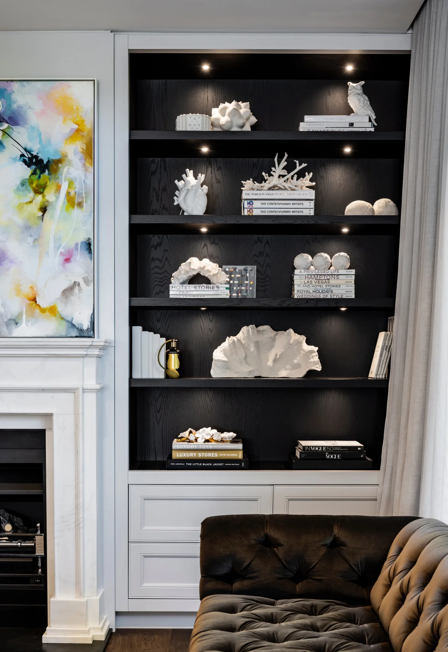 Nicole Gazal O'Neil's formal living room featuring black shelves and white decor.