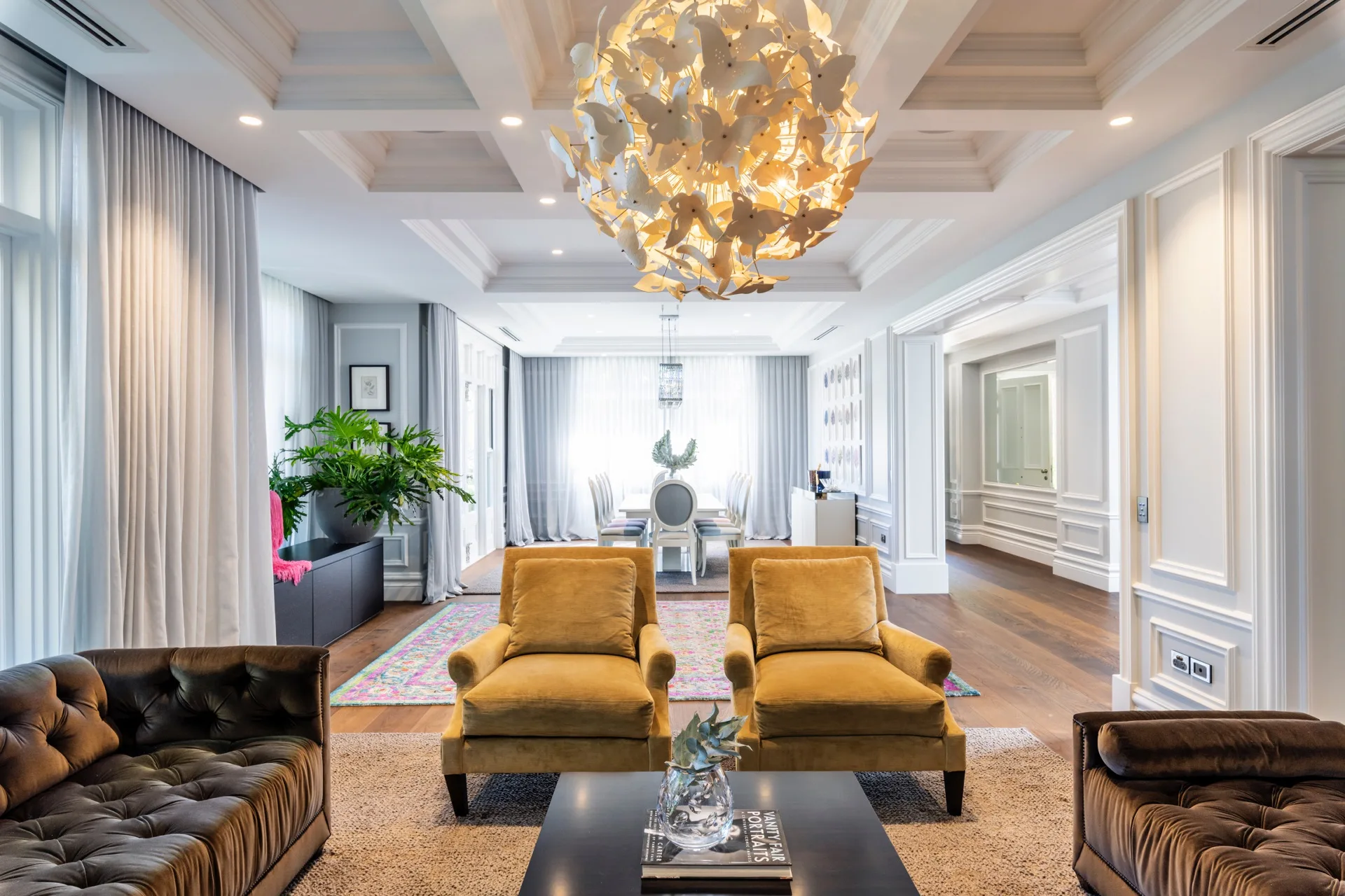 Nicole Gazal O’Neil’s formal living room features a brown sofa, a daybed, camel-coloured armchairs and a butterfly chandelier.