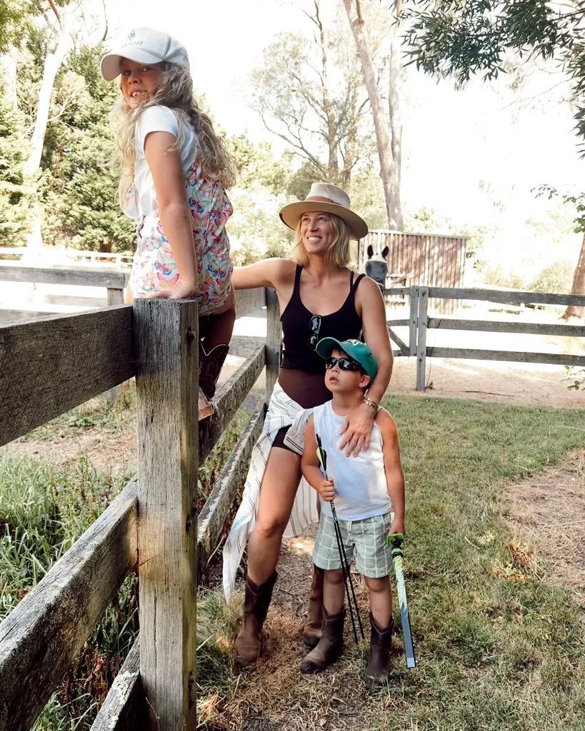 Phoebe Burgess with two children playing on a fence at her burradoo home for sale