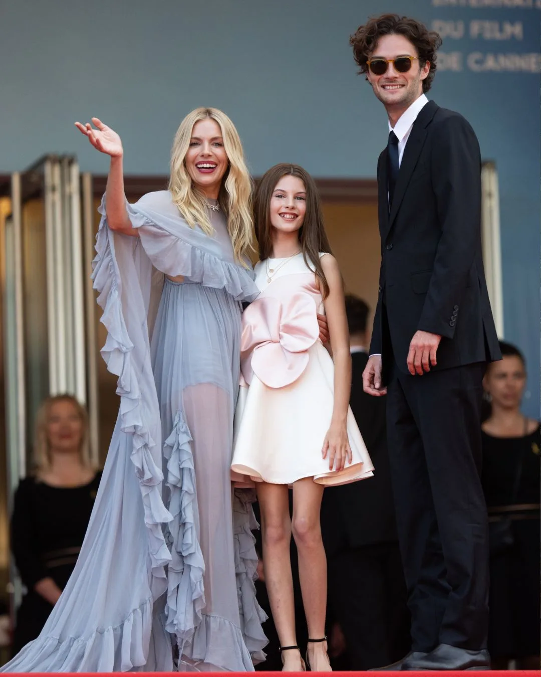 Sienna Miller waves on the red carpet with her daughter Marlowe and partner Oli Green