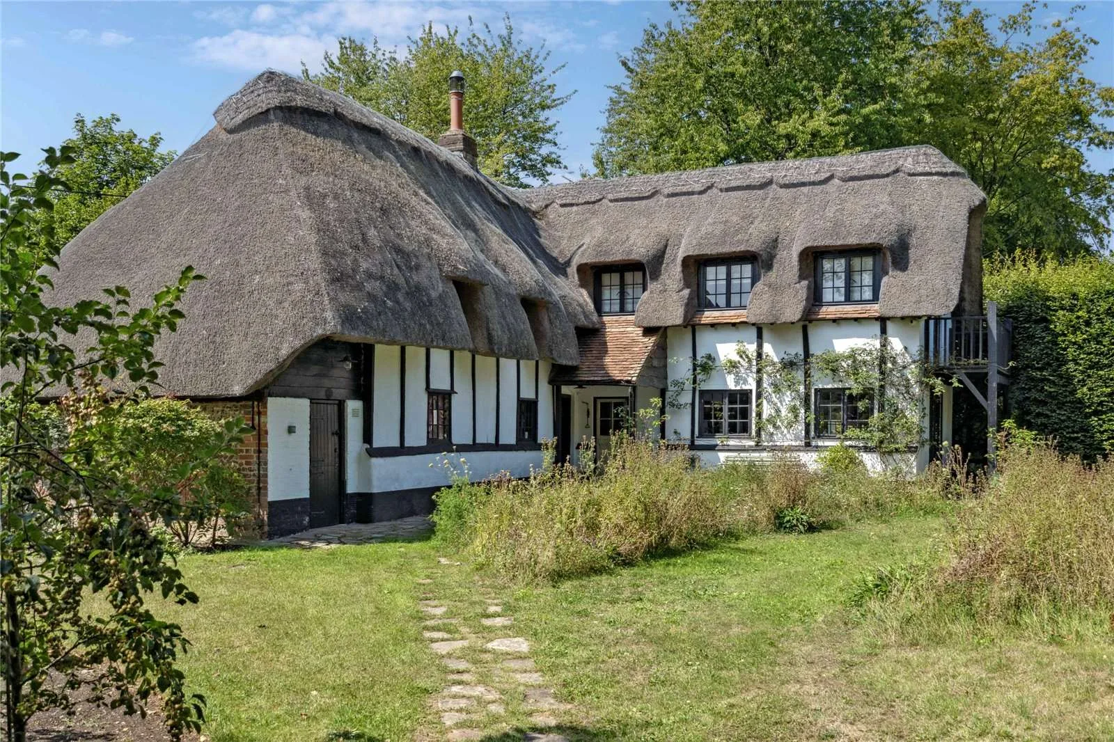 Sienna Miller's country cottage, a multi-level tudor home with a thatched roof