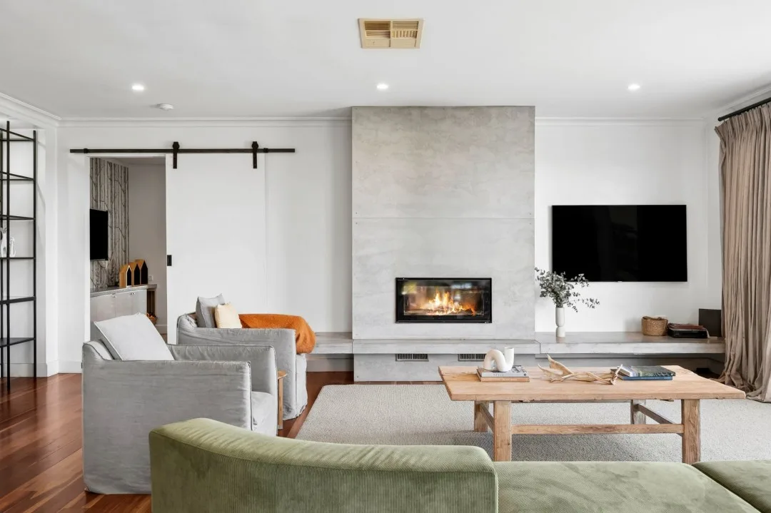 Tom Hawkins' Barrabool farm house featuring a family room with a concrete fireplace and green sofa