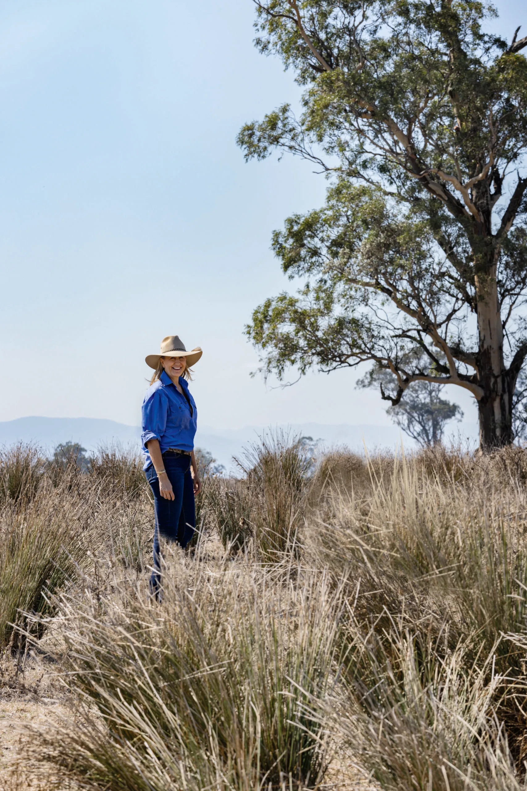 Adelaide Bragg stands in the bush. 