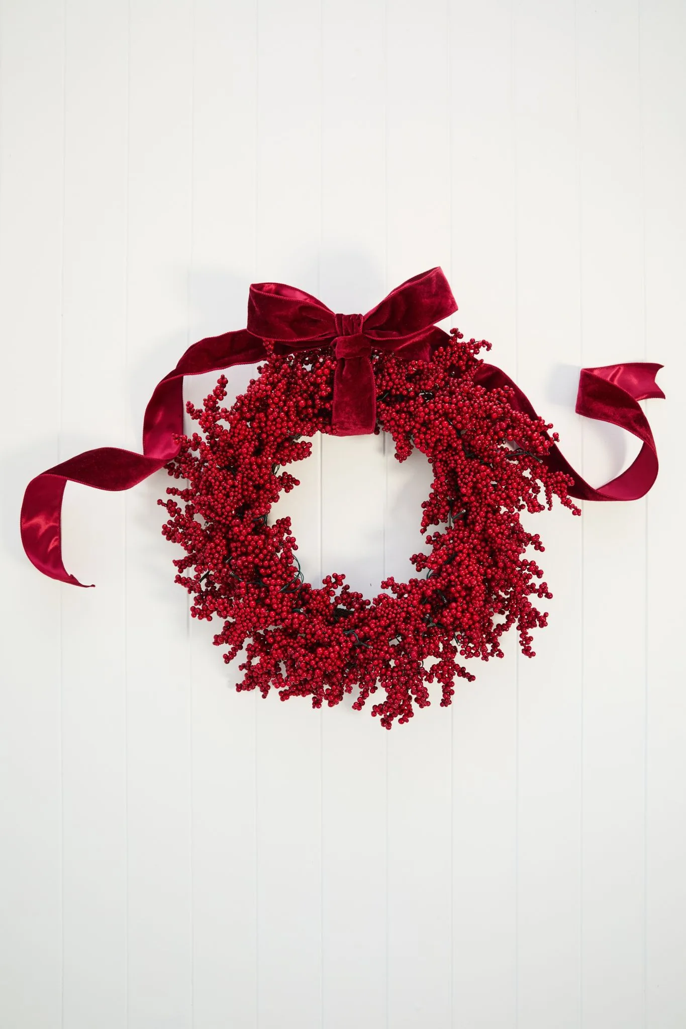 Berry wreath on white door. 