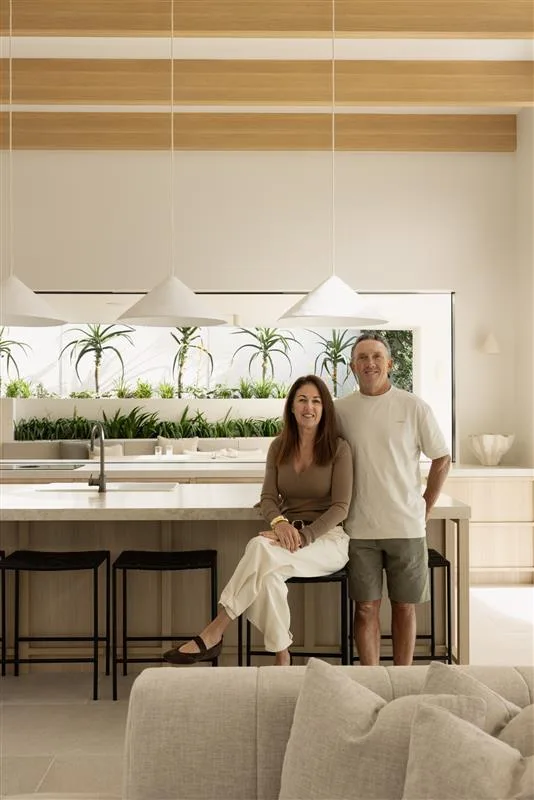 Owners Justine and Andrew in the kitchen of their coastal Sydney house with a neutral, beige Mediterranean aesthetic.