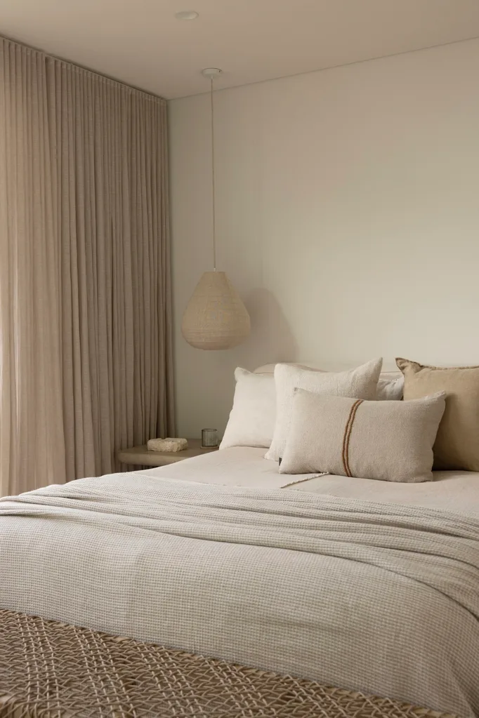 Bedroom in a coastal Sydney house with a neutral, beige Mediterranean aesthetic.